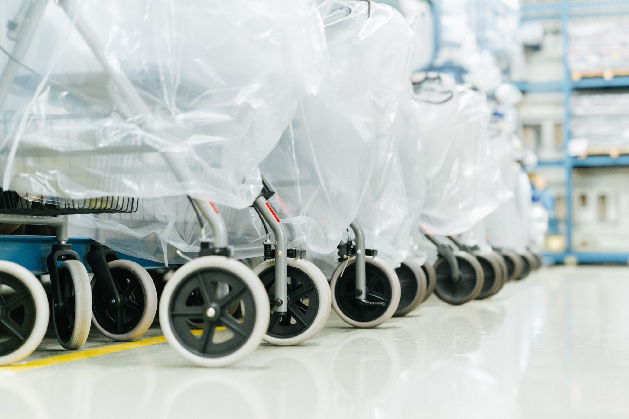 Verpackte Rollatoren und Rollstühle stehen aufgereiht im Carenetic Lager