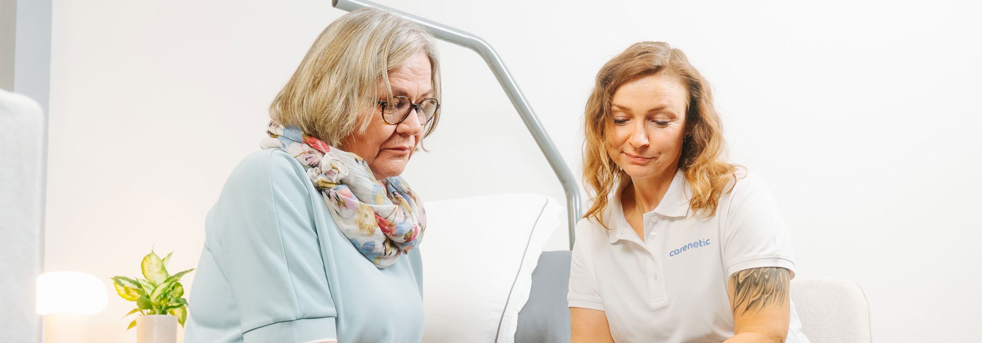 Carenetic employee talking with a patient at the care bed