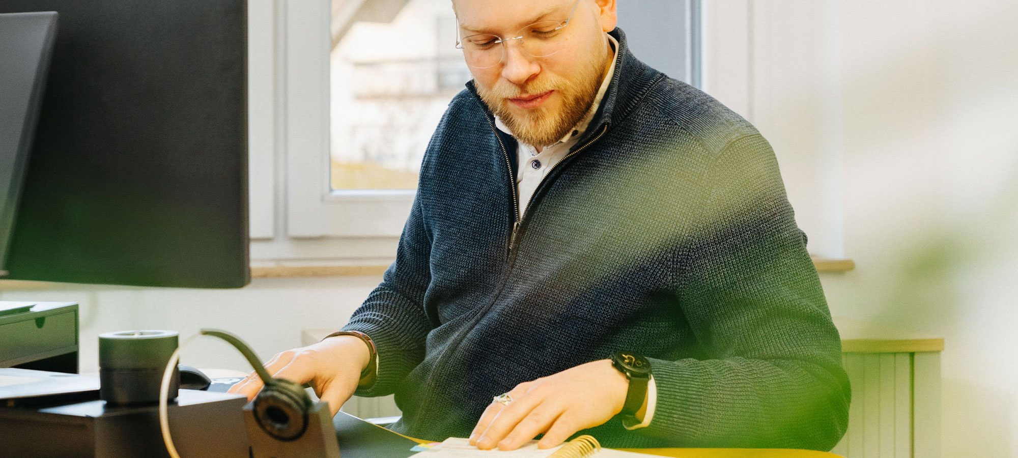 Carenetic Mitarbeiter bearbeitet am Schreibtisch eine Versorgungsanfrage